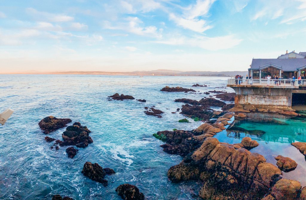 sunset over blue and green tidepool in monterey bay
