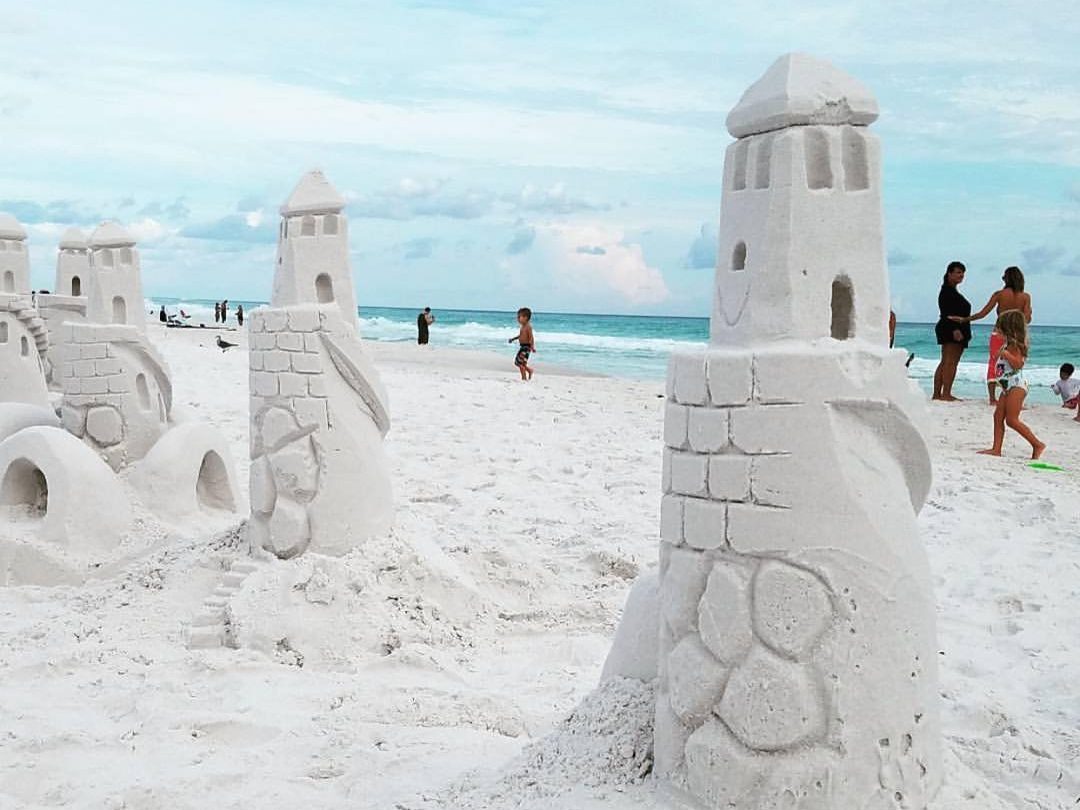 Sandcastle towers on a white sandy beach made by a family on a florida roadtrip with kids