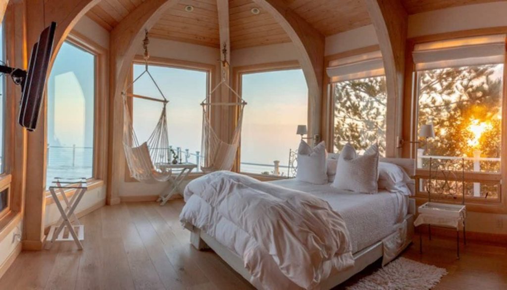 Large bed and personal hammocks hang in a luxurious Airbnb on the Oregon coast