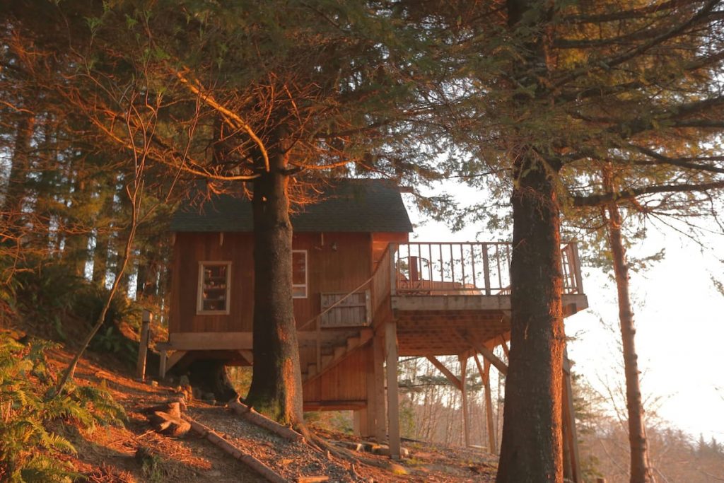 Oregon Coast Airbnb Treehouse sitting on top of a hill with a large deck