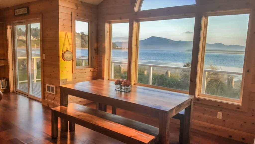 Large windows look out from inside cabin overlooking the ocean