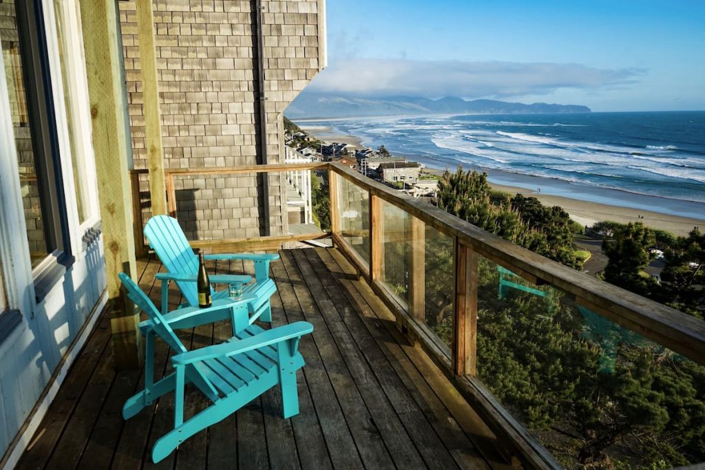 Two chairs overlook ocean from wooden deck high above