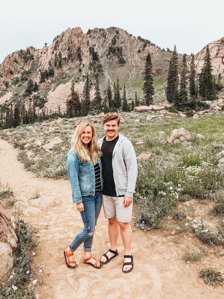 Man and woman on trail in front of mountain peak