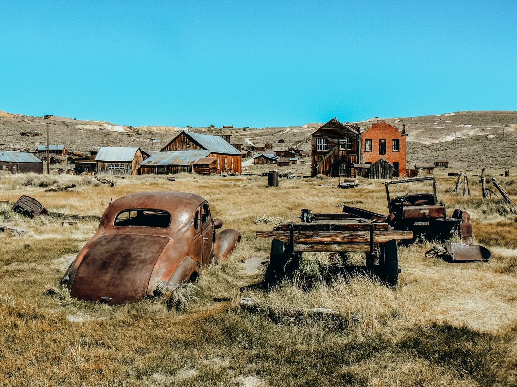Antique cars and buildings in field at Bodie California State Historical Park