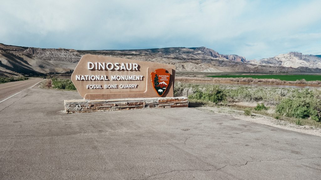 Dinosaur National Monument Sign with  mountains in the background