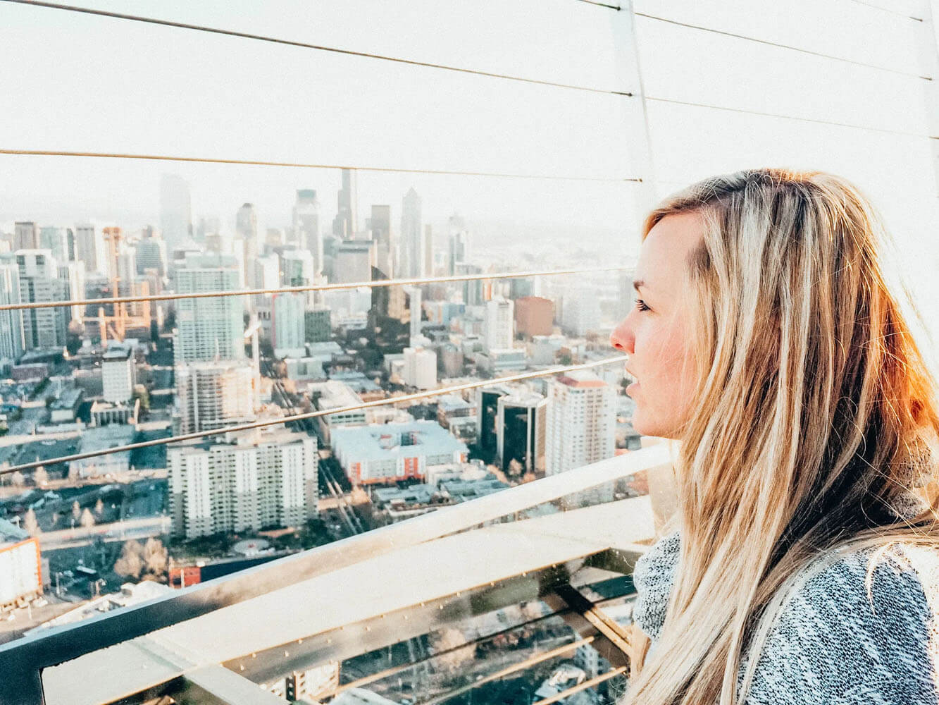Woman looks out at city of seattle from high above in the Space Needle