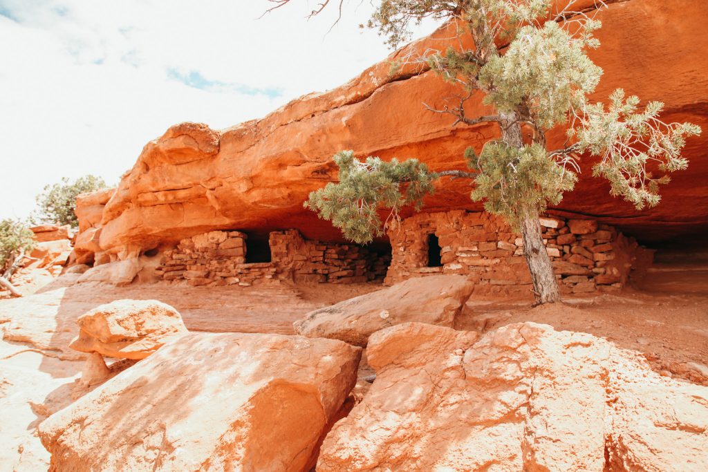 Sandstone rock with bricks made of sandstone stacked to make two rooms with 2 windows