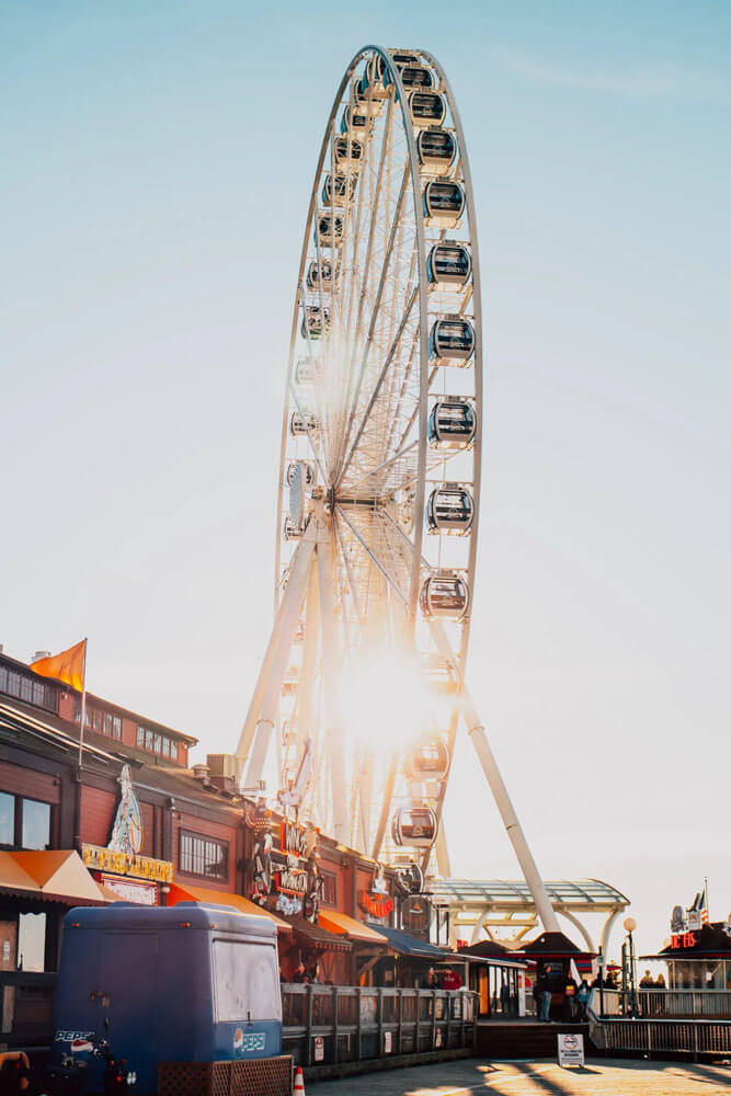 Large white ferris wheel rotates at sunset