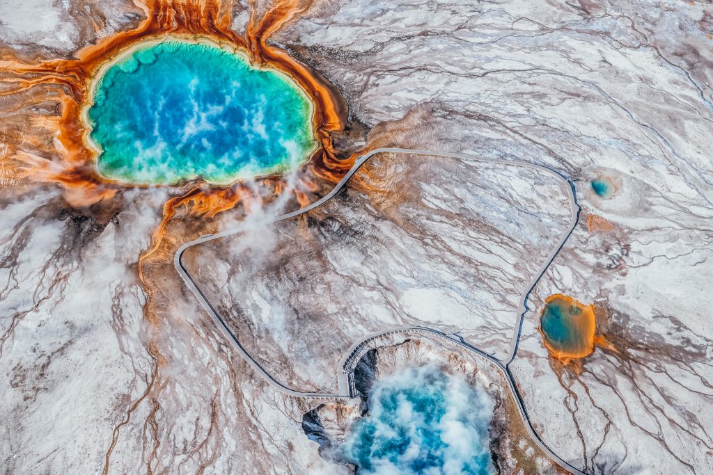 Aerial view of Grand Prismatic spring and other springs along colored blue, green, yellow and orange. This is one of the best things to see in Yellowstone National Park