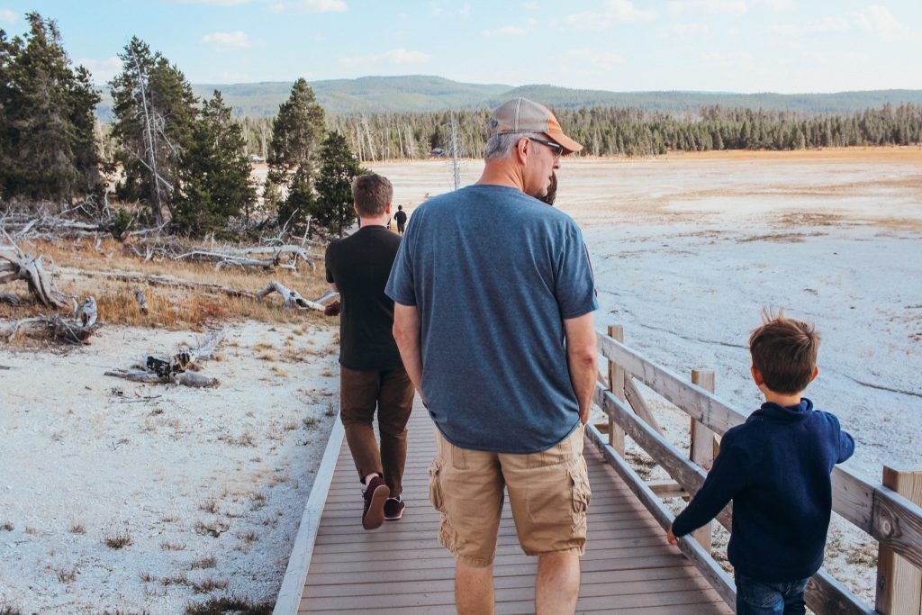 Man and boy walk down boardwalk in nature