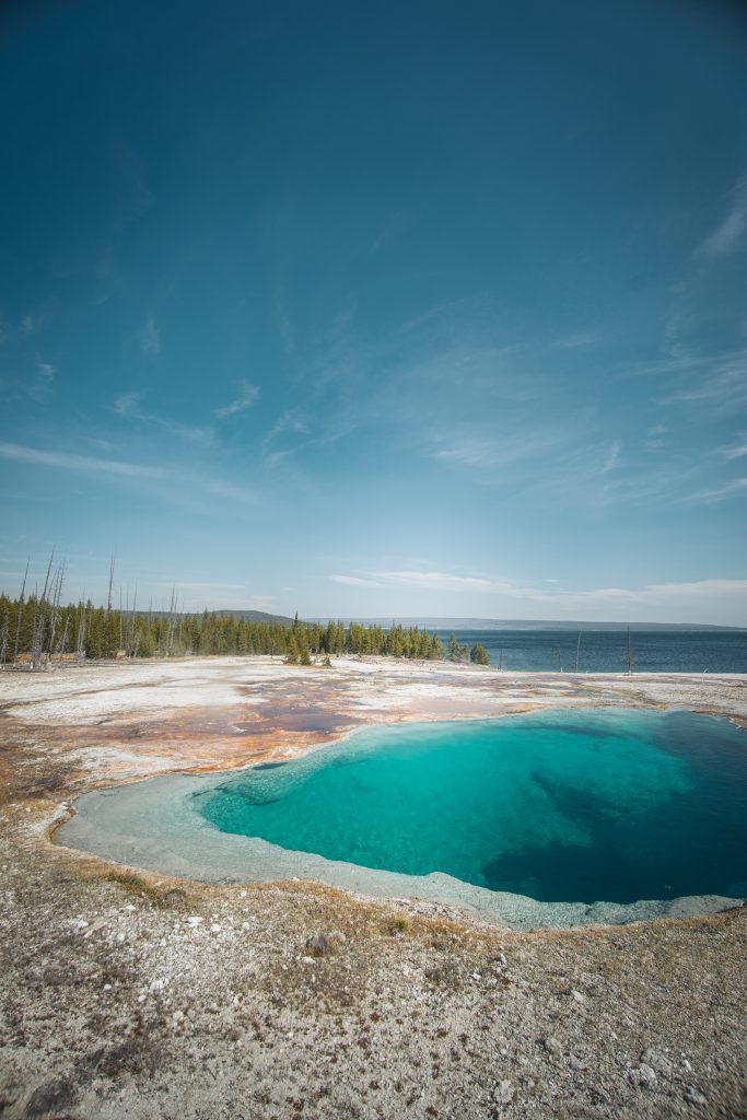 Deep hole of clean bright blue and green water near Yellowstone lakes edge