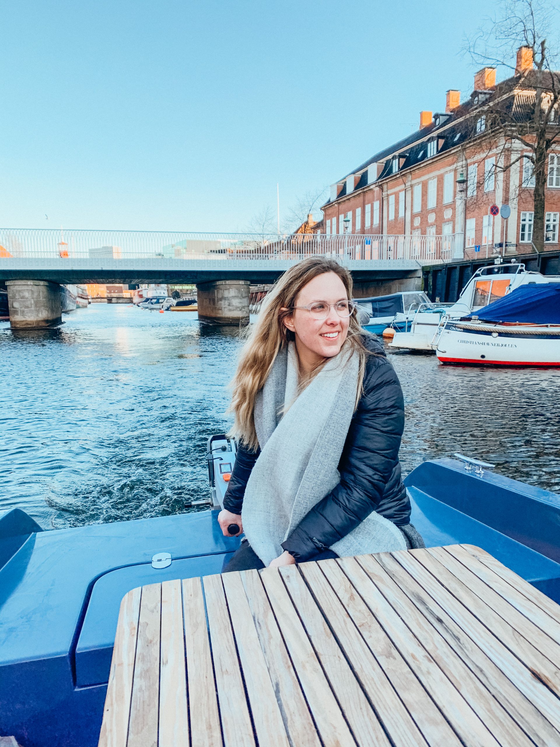 Woman steering small boat in Copenhagen harbor