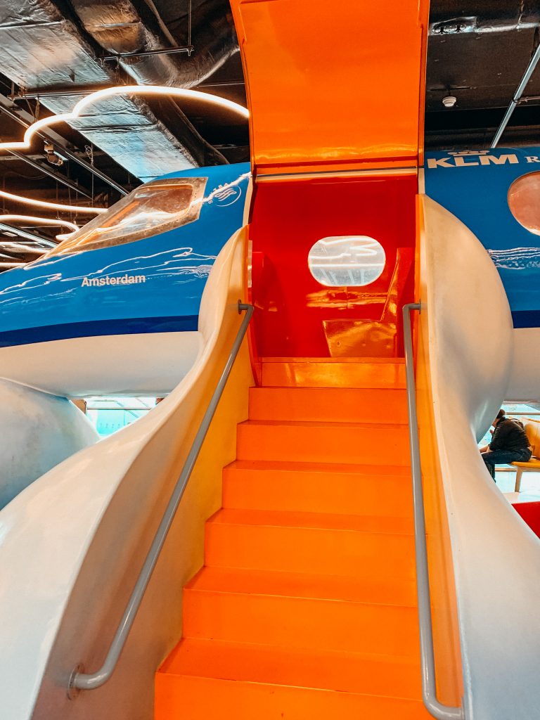 Orange stairs lead up to blue and white playground airplane