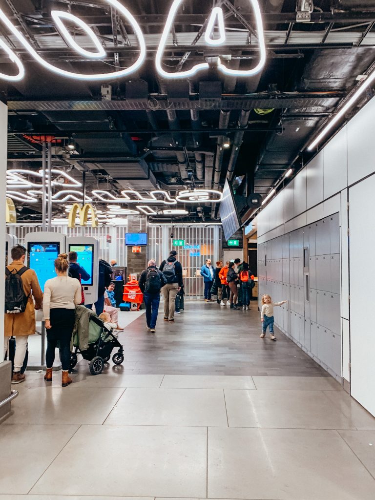 People wait in line at digital kiosks at McDonalds in the airport.