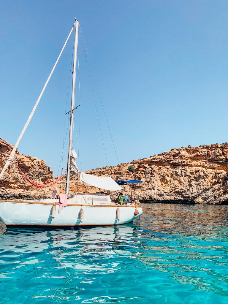 White sailboat floats in bright blue water