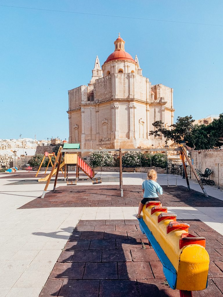 Large, stone church in the distance with play equipment in the foreground