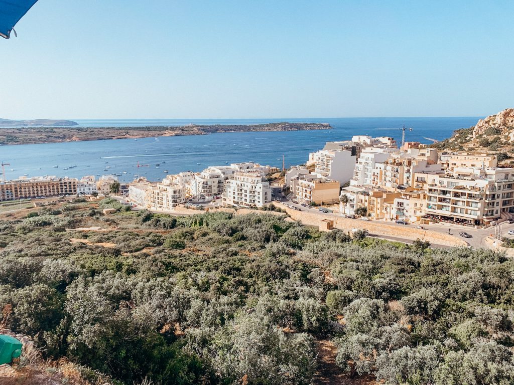 Landscape shot of white buildings leading down to the sea