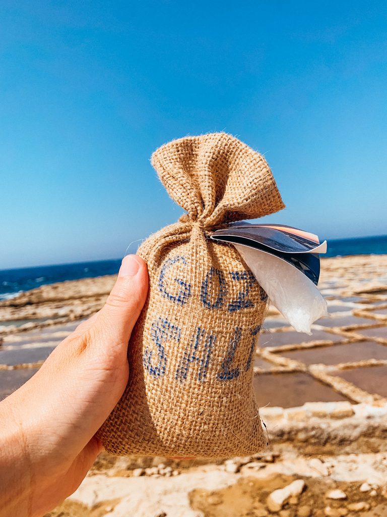 Hand holds up burlap sack with the words 'gozo salt' written on it