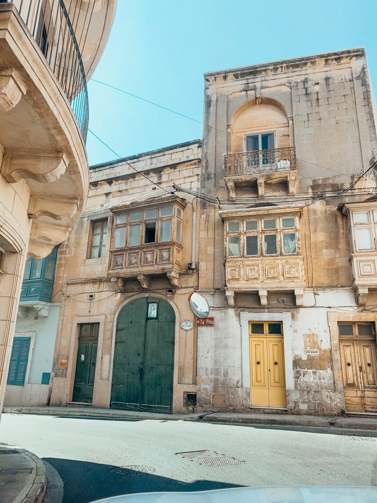 Tan cement buildings with green, blue and yellow doors