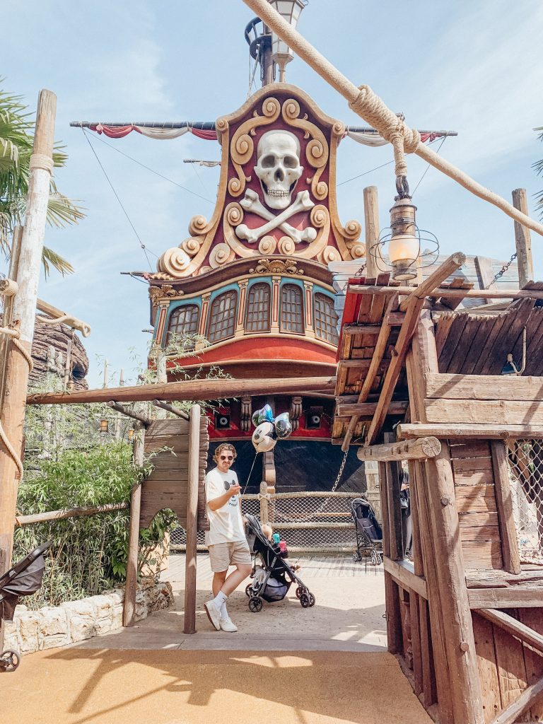 Man stands with stroller at playground at Paris Disneyland