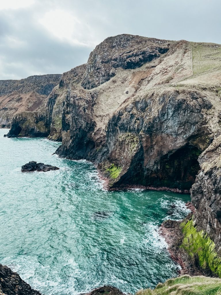 Green sea cliffs meet the bright green sea