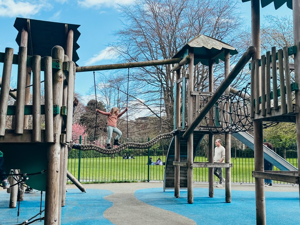 Child plays on a wooden playground at St. Stephen's Green in Dublin