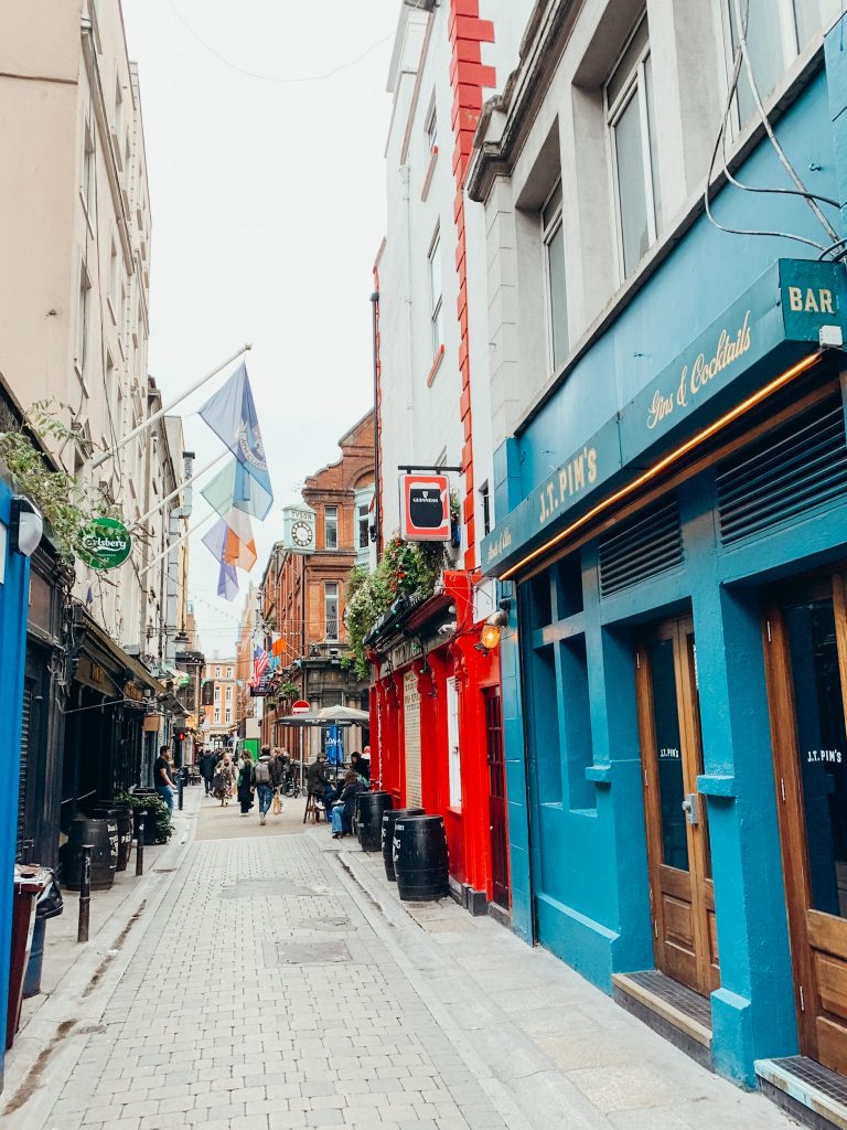 Blue and red buildings line a small pedestrian street in Dublin