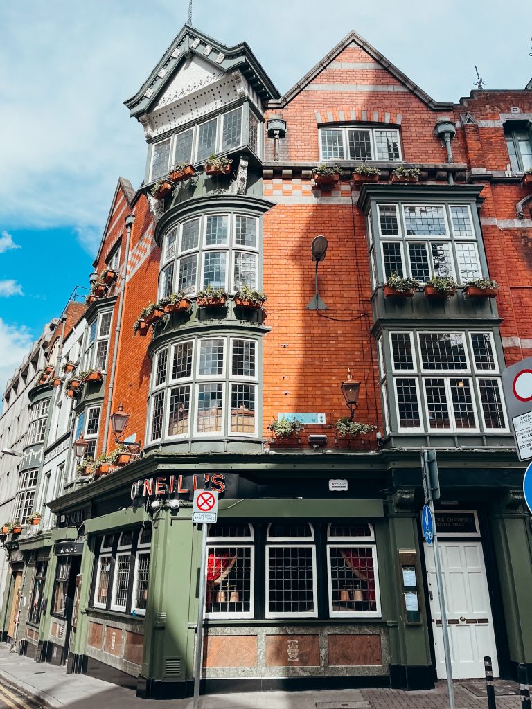 Green and black building with orange bricks on a corner in Dublin