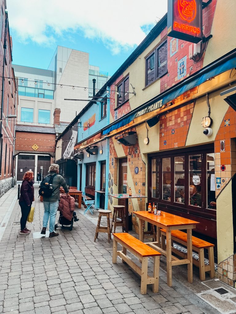 Yellow, orange and blue buildings line a small pedestrian street in Dublin