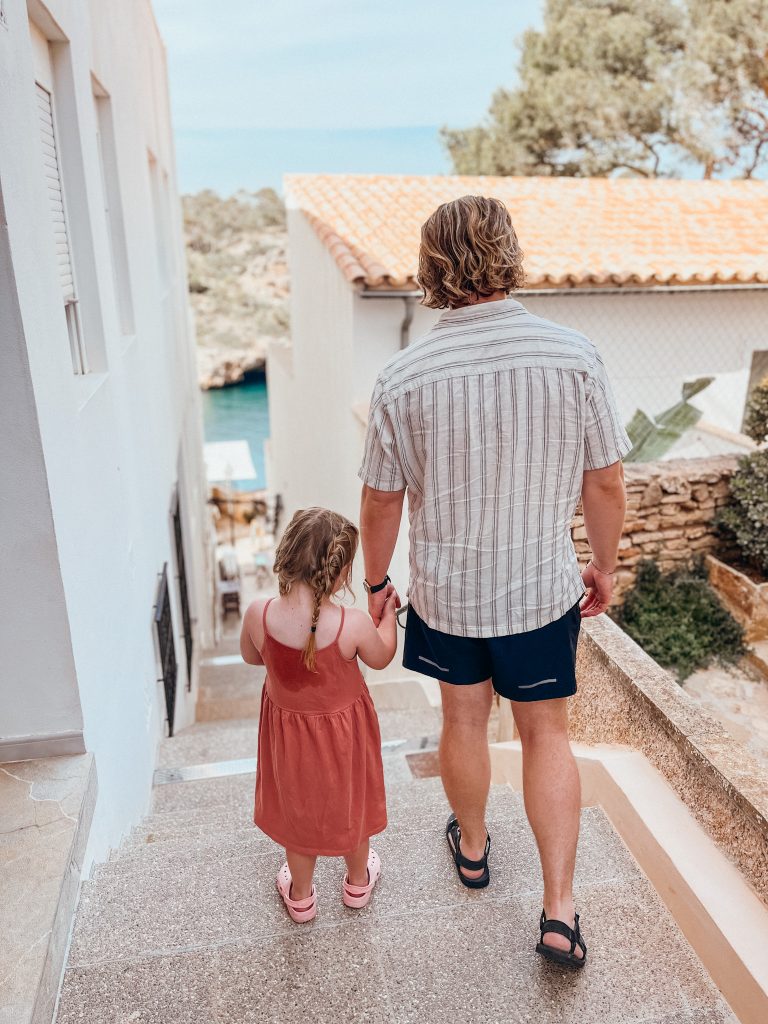 Man and child walk down stairs hand in hand
