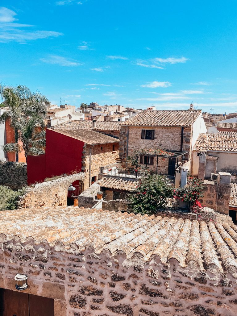 View of rooftops and stone homes with greenery in Alcudia Old Town