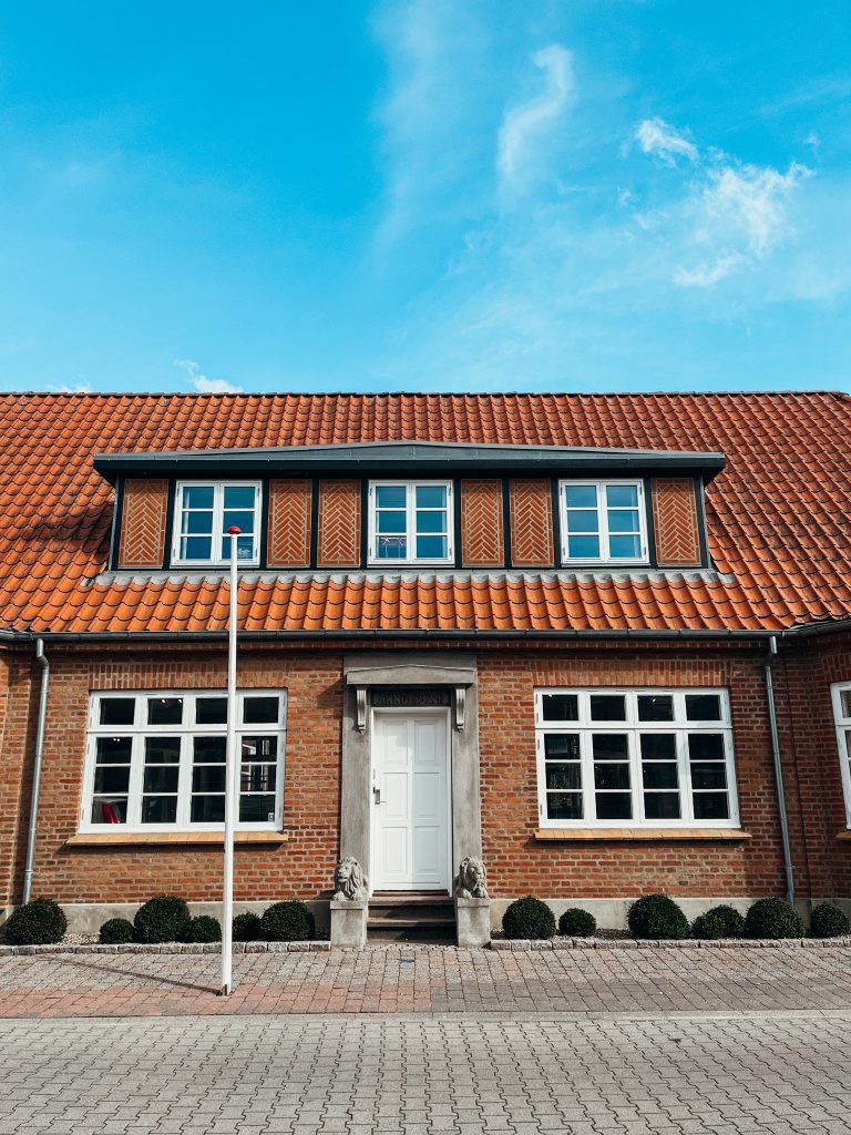 Brick building with white windows and orange tiled roof in Billund Denmark