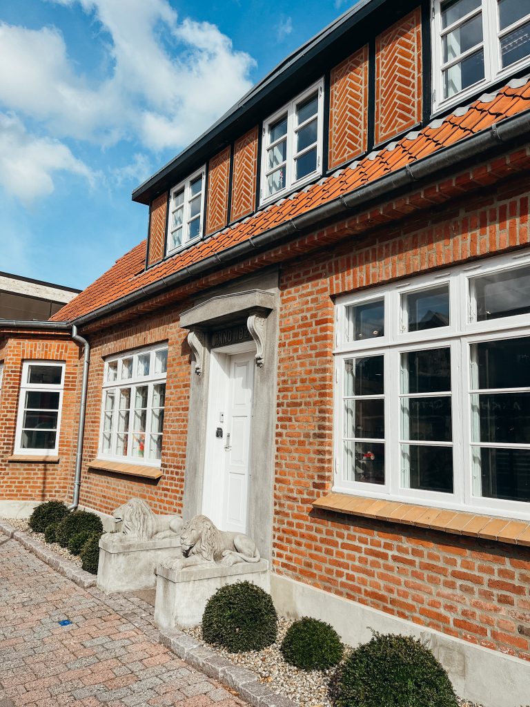 Brick building with white windows and orange tiled roof in Billund Denmark