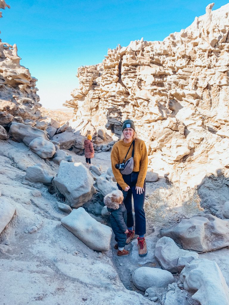 Woman and two children stand in amongst rock spires with unique shapes in the desert