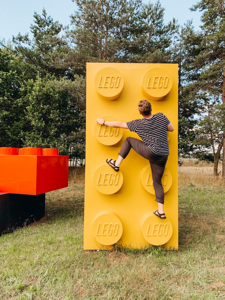 Man climbs on large, colorful LEGO bricks in Billund Denmark