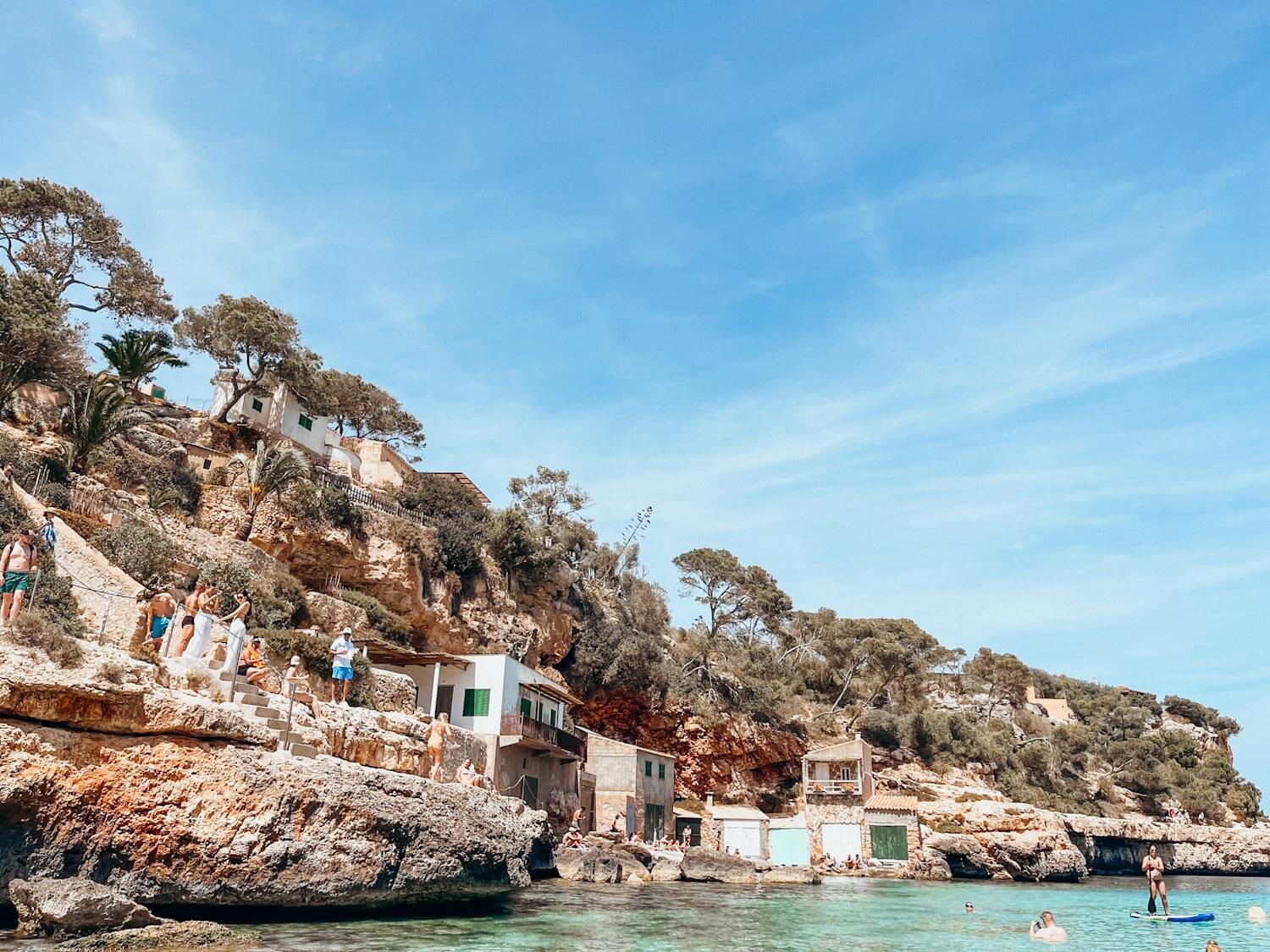 Colorful fishing villages on cliffside next to bright green water