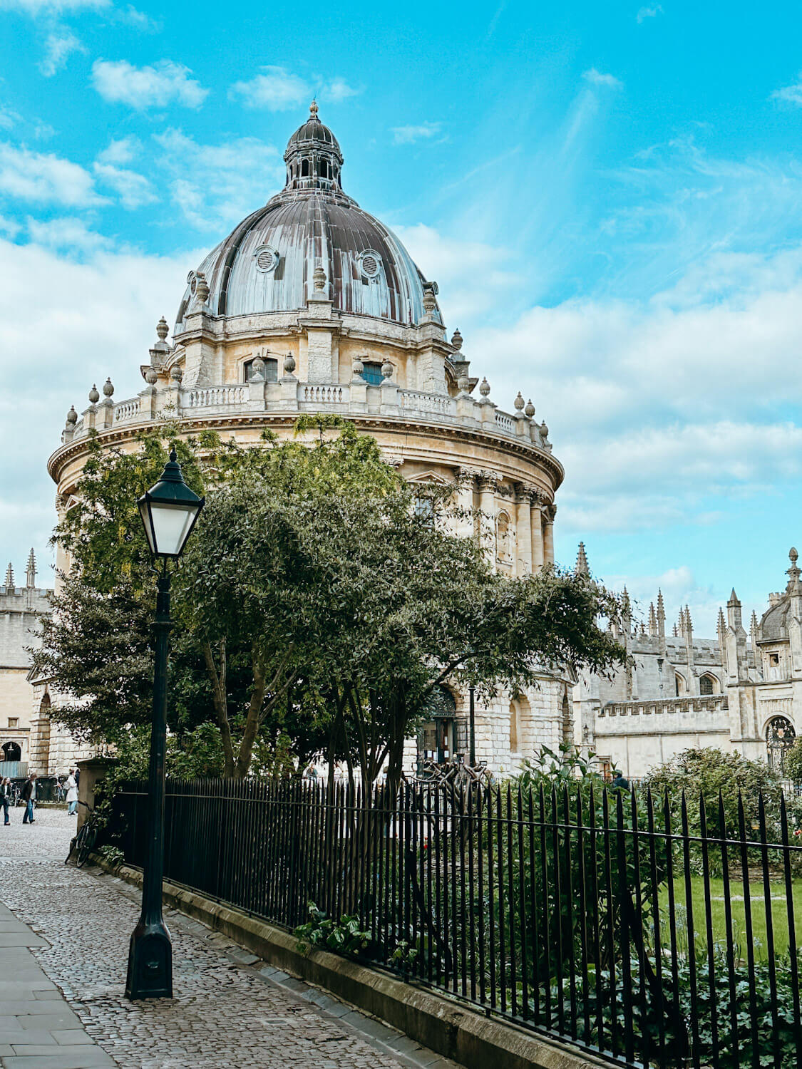 Large circular, stone building in Oxford with black lampost in foreground