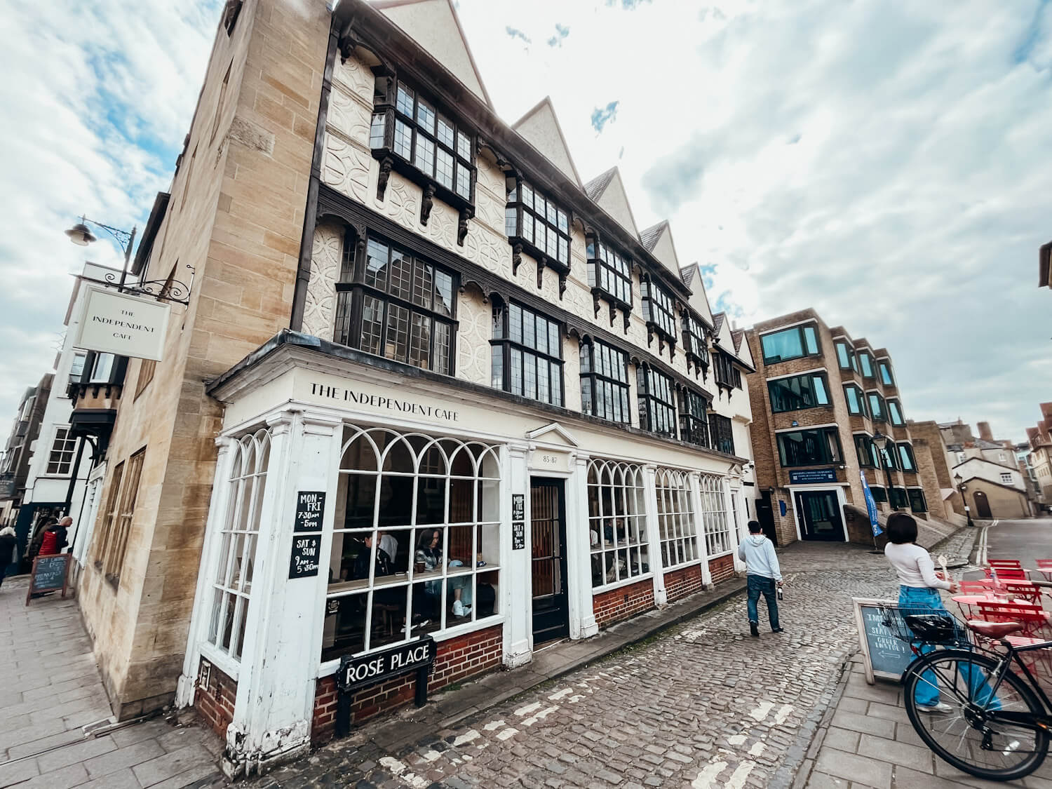 Old wooden and stone building with white storefront called 'The Independent Cafe'
