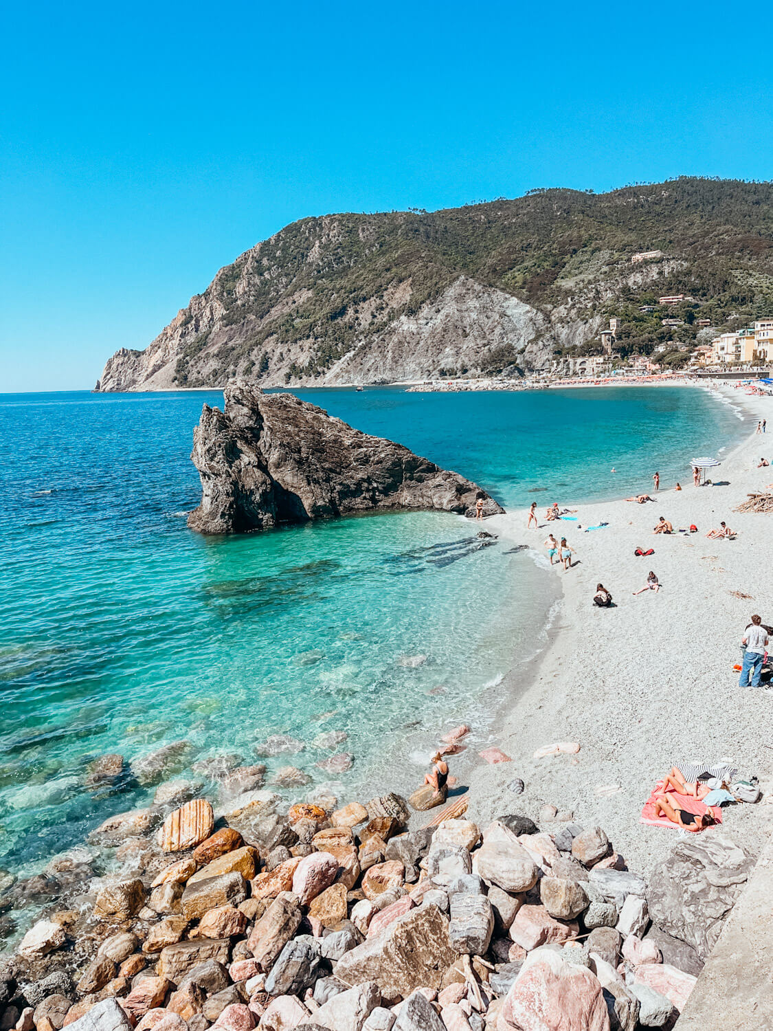 Large rock along beach in turqouise water in Cinque Terre Italy
