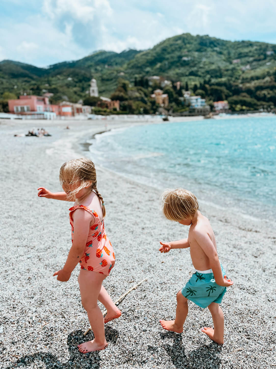 Two children walk along beach in Levanto Italy