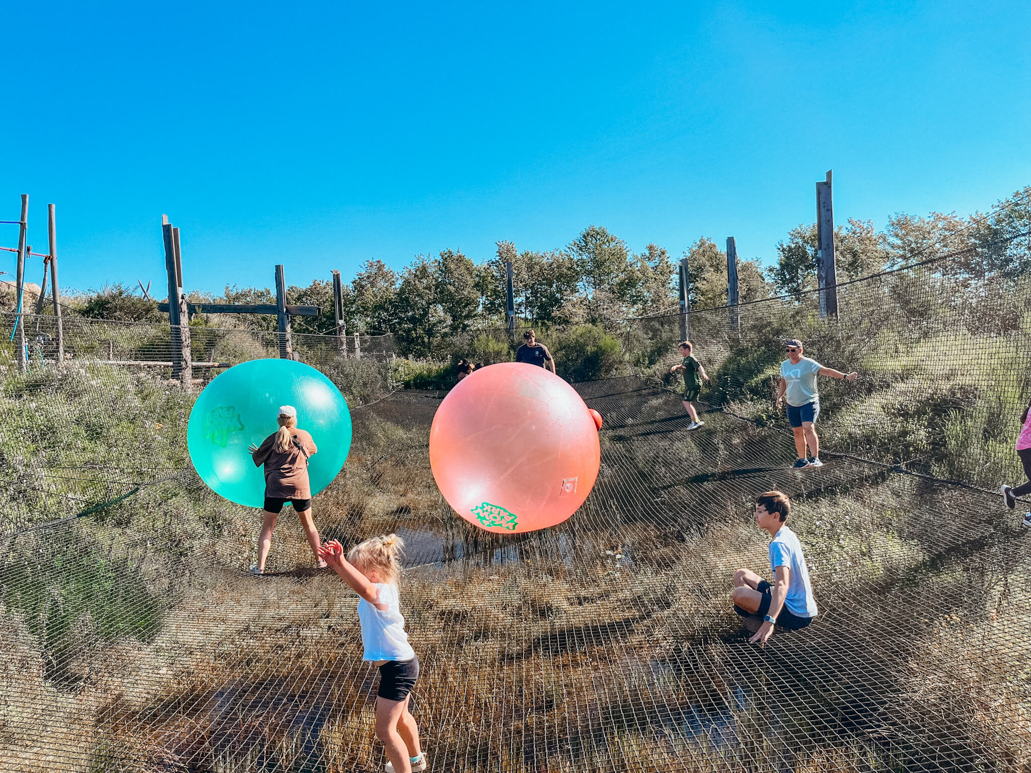 Large roped trampolines with large green and pink balls at WOW Park in Billund Denmark