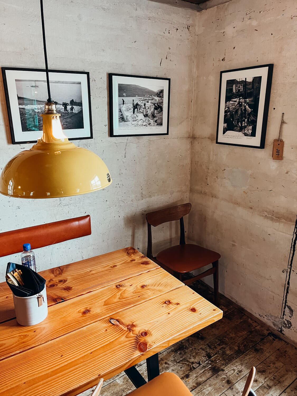 Wooden table with a yellow lamp at a restaurant in the Faroes: Fiskastykkid