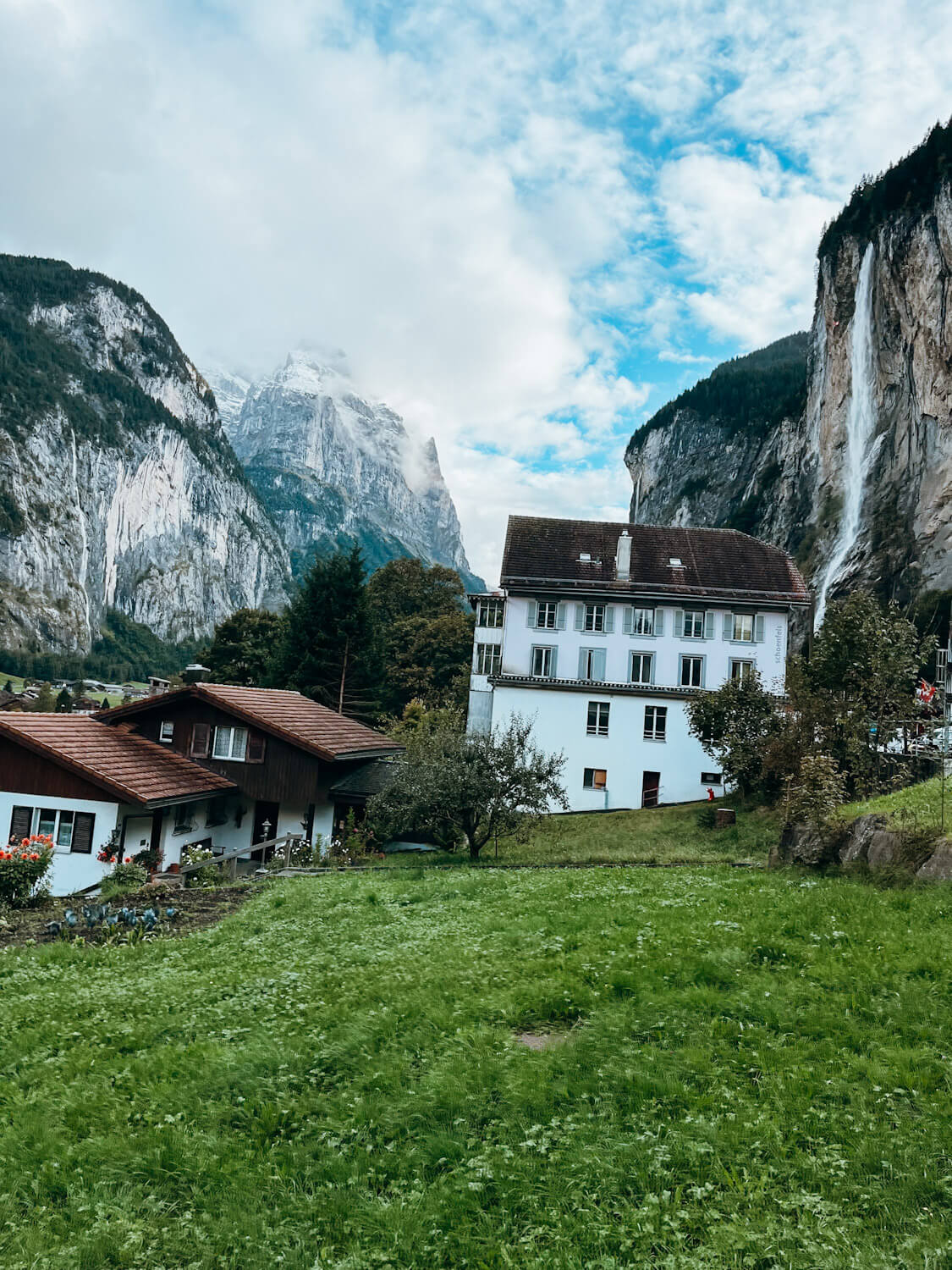 View of Swiss buildings with cliff with waterfall falling down cliff edge