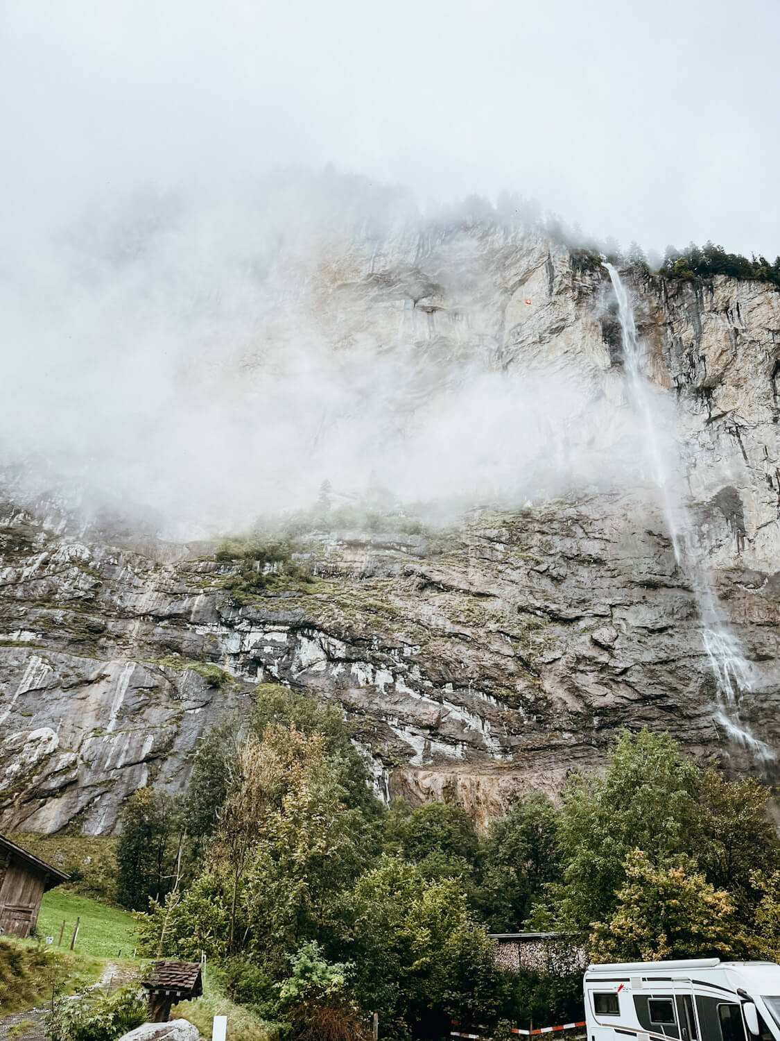 Waterfall falls down cliff side in Lauterbrunnen Switzerland