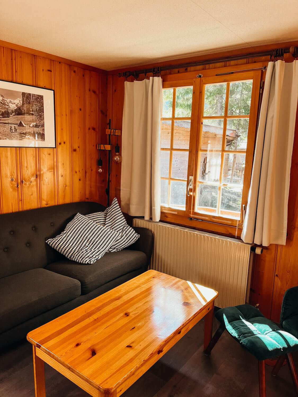 Grey couch and green chair in the bungalows at Camping Jungfrau