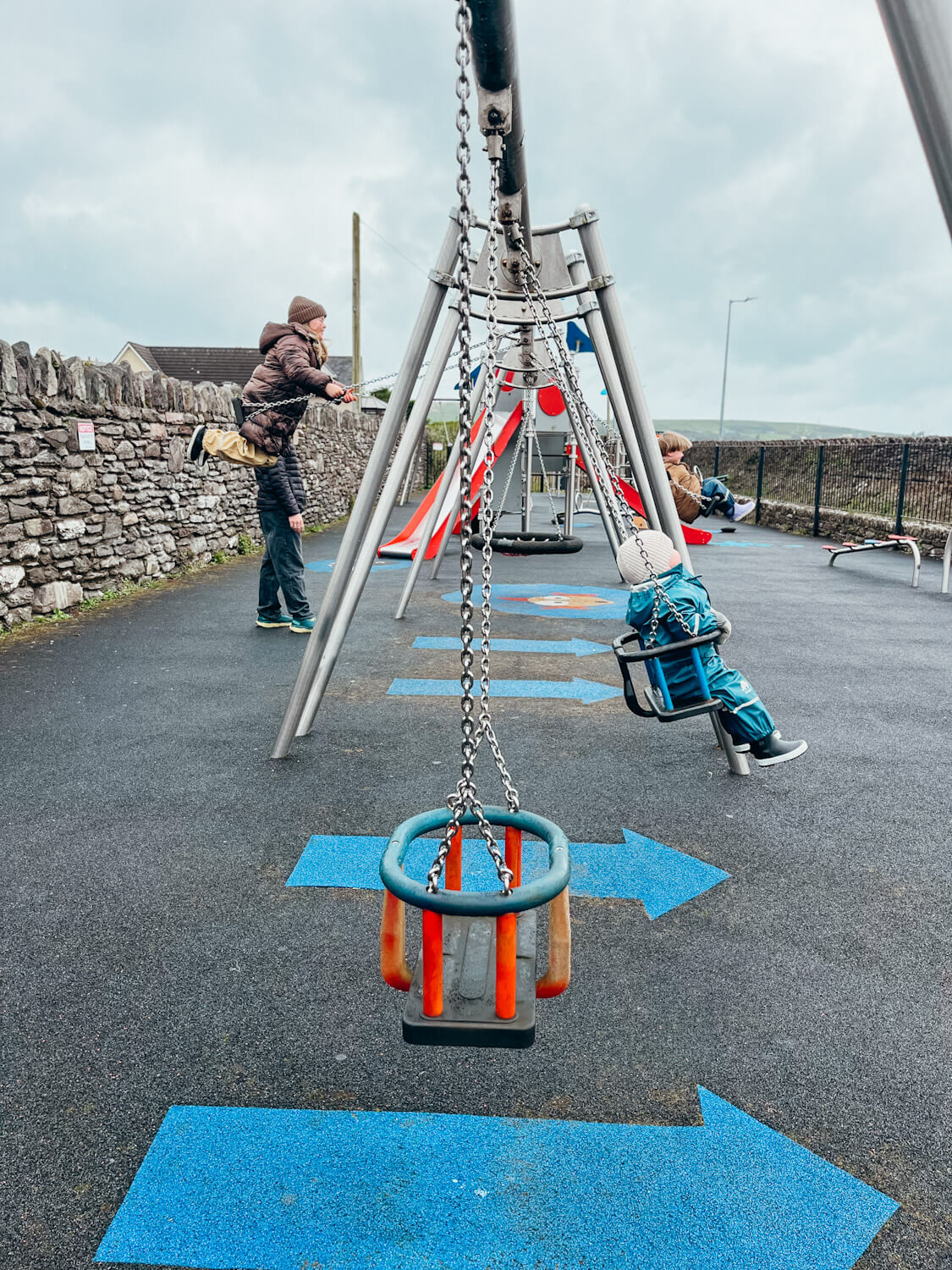 Children swing on swing set a the Dingle playground