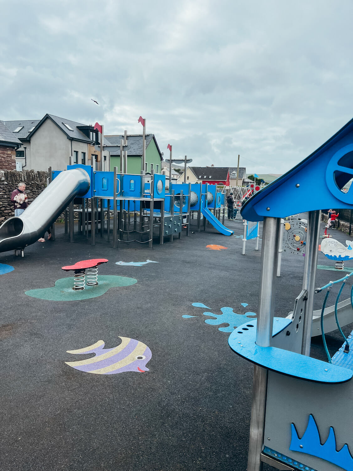 Blue and silver play structures at playground in Dingle Ireland as a family