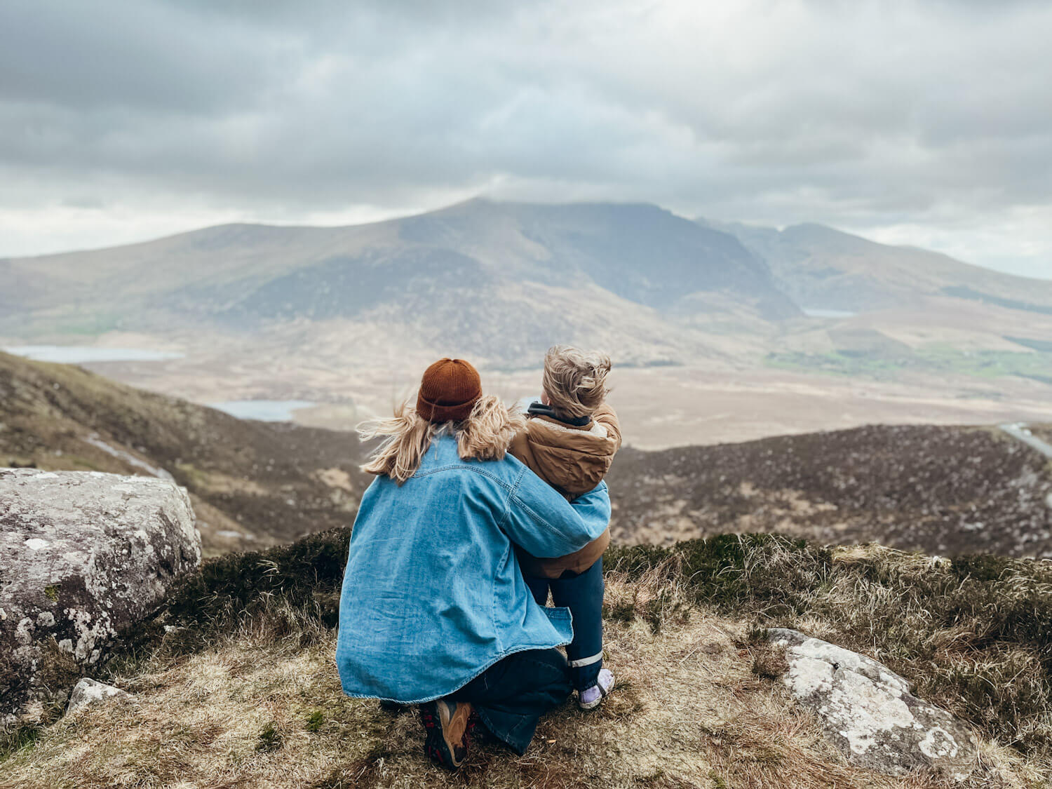 Woman and child look out over view of mountains and lakes on Conor Pass in Dingle with kids