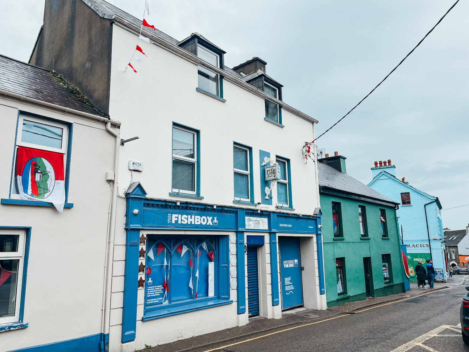 White and blue and green buildings lining a street in Dingle Ireland