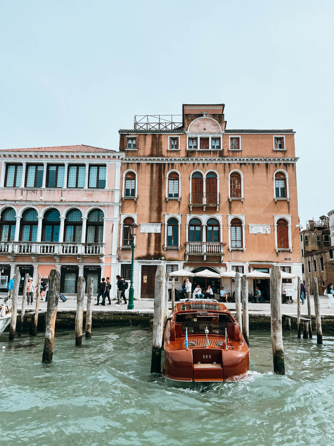 Wooden taxi boat in Venice docked in front of an old orange building